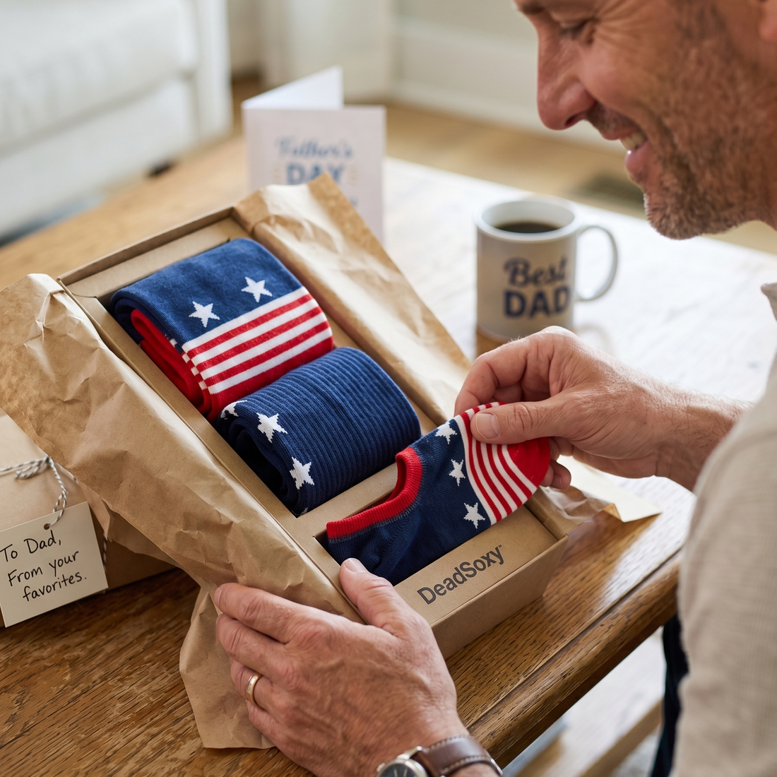 Man opening a gift box with American flag-themed socks on a Father's Day card.