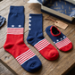 Set of red, white, and blue socks on a wooden surface with packaging.