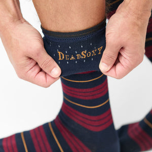 Navy dress socks with deep red stripe and gold accents showing TrueStay‚Ñ¢ grip in welt