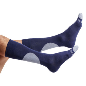 1 navy dress sock with a single large grey dot on the calf shown on legs coming into the image from the left
