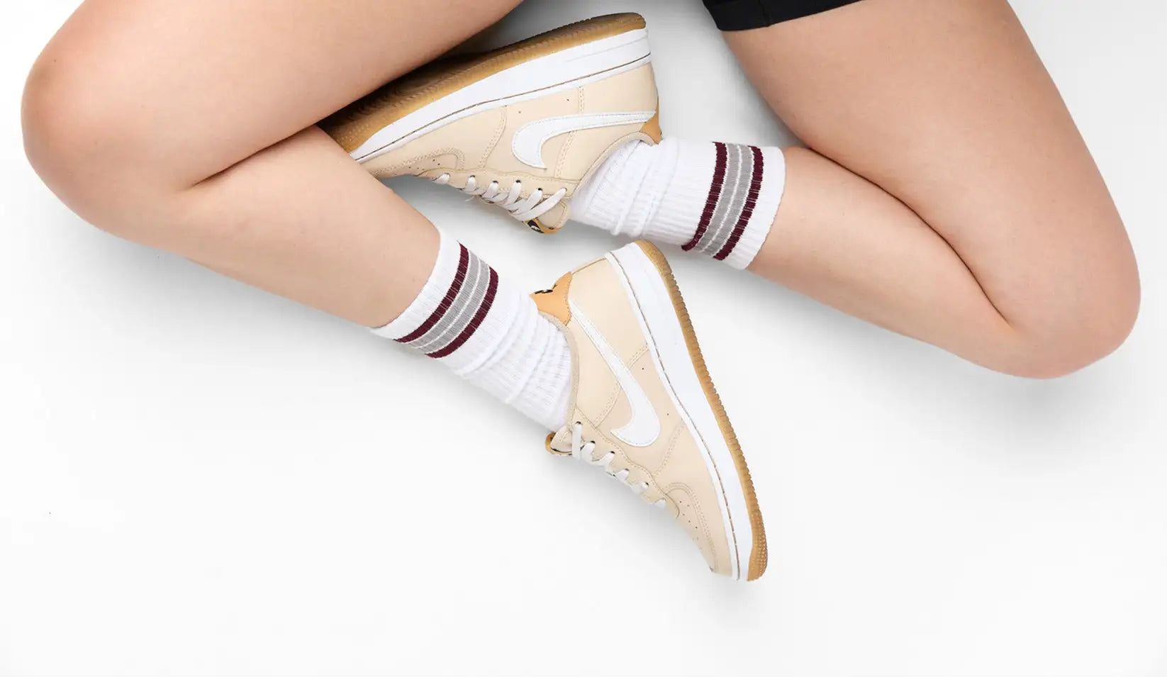 Beige nike air jordan 1 low sneakers with white laces and a tan rubber sole.