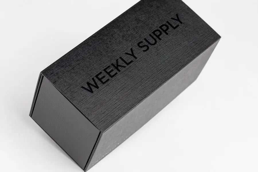 Black rectangular box with textured surface and embossed ’weekly supply’ text.