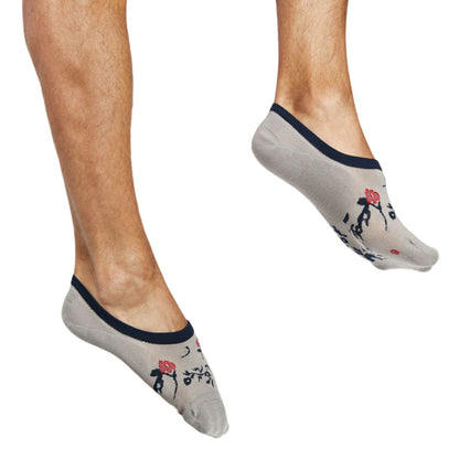 1 pair of no show socks in solid white with a navy blue and red floral pattern and navy blue welt worn by model on feet
