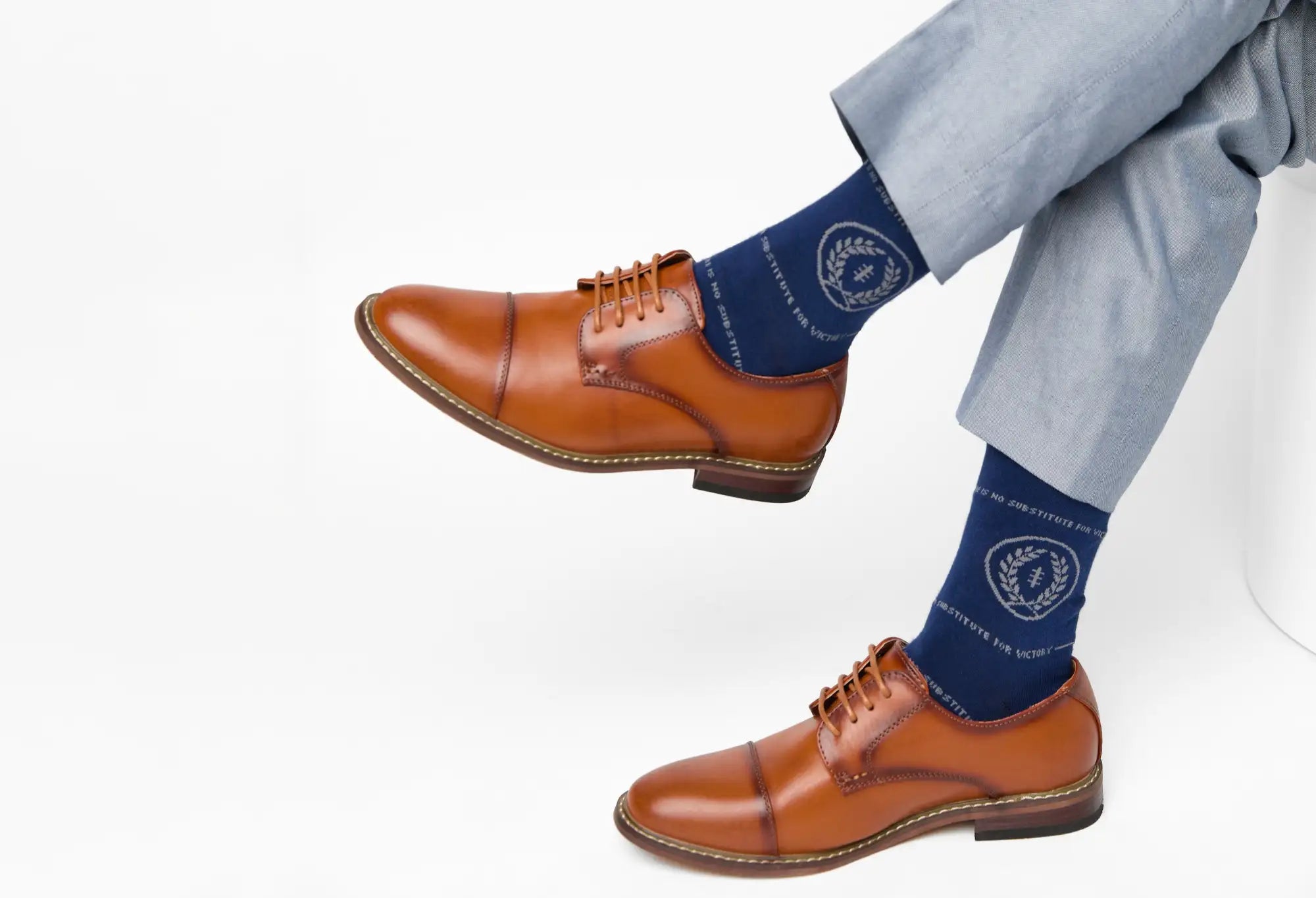 Brown leather cap-toe dress shoes with tan laces and a dark brown sole.