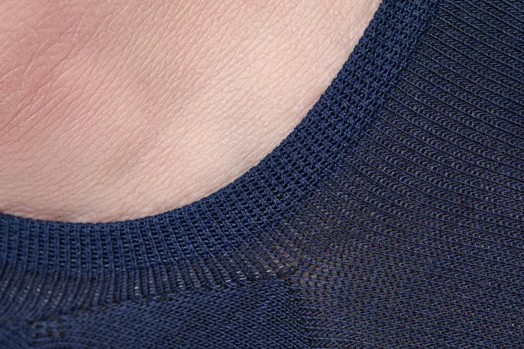 A close-up of a navy blue ribbed knit fabric, likely from a sweater or top.