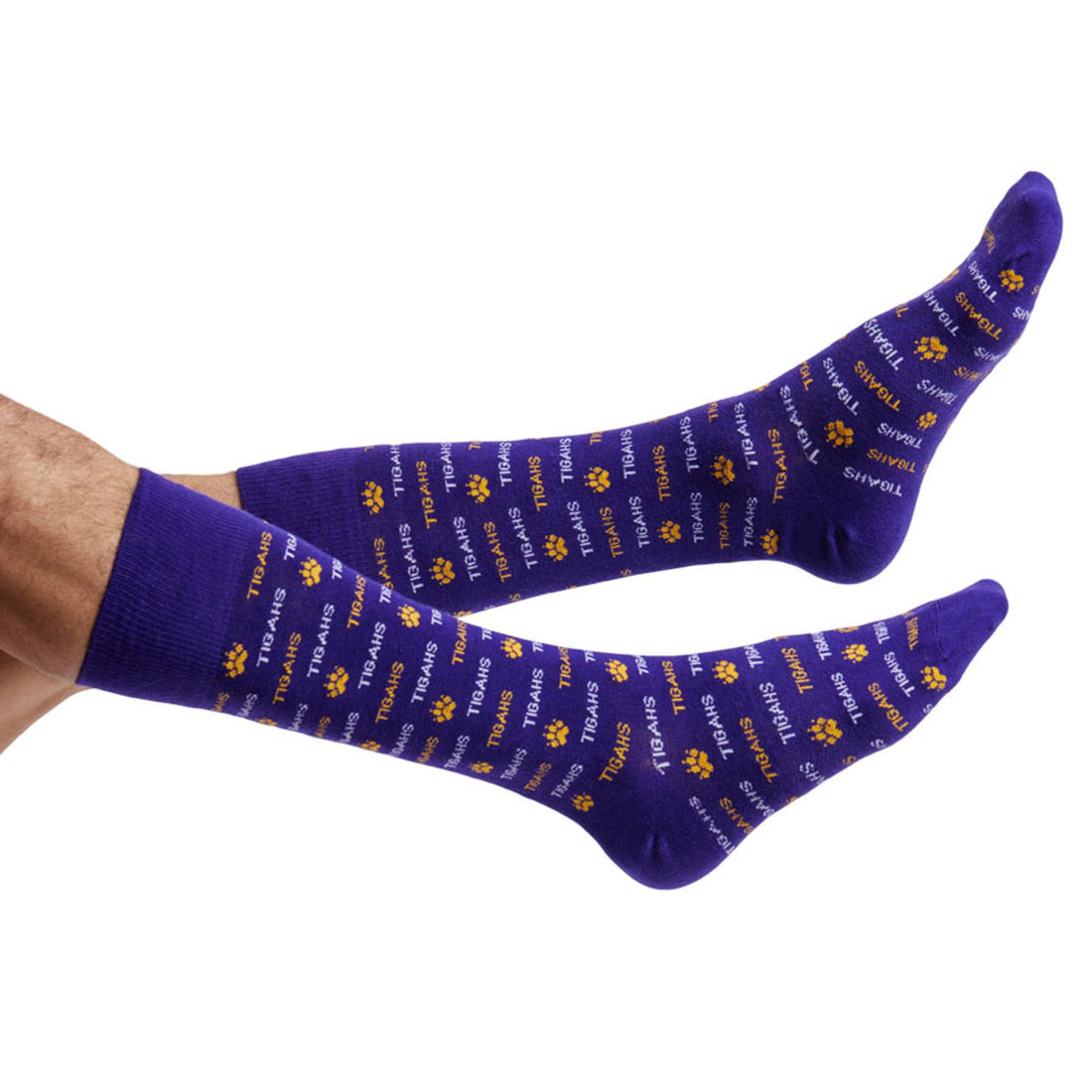 Purple and gold dress socks with a the word Tigahs written in stripes and separated by a small tiger print organized as stripes shown on legs coming into the left side of the image