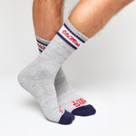 Grey casual crew socks with Ole Miss script on the leg and two retro stripes shown on legs.
