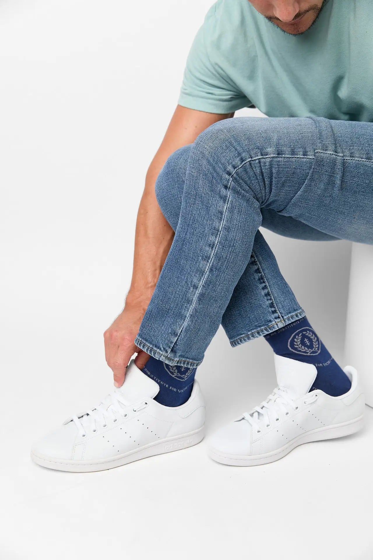 Navy blue socks with white laurel wreath embroidery and ’the world’s finest’ text near the cuff