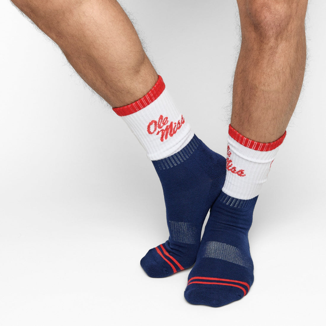 Navy and White 50/50 design with Ole Miss script on the side of the calf shown on male legs standing crossed