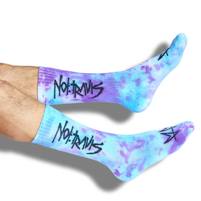 Not.Travis casual collab socks with blue and purple tie dye design shown on legs.