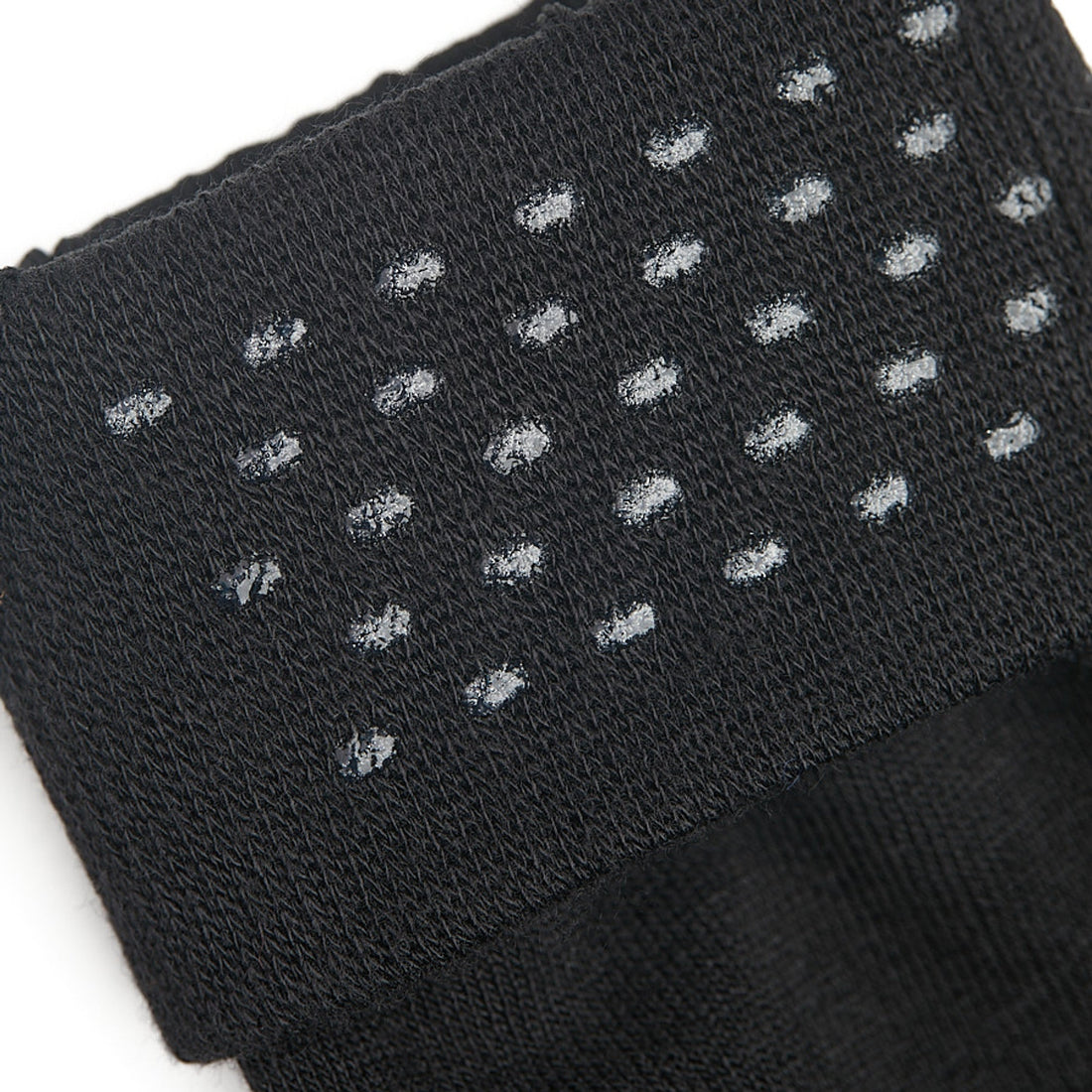Close up shot of black sock welt featuring clear silicone dots