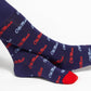Licensed navy blue dress socks with the Ole Miss script logo in red and powder blue blue in repeating pattern shown close up.
