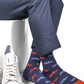 Licensed navy blue dress socks with the Ole Miss script logo in red and powder blue blue in repeating pattern shown close up.