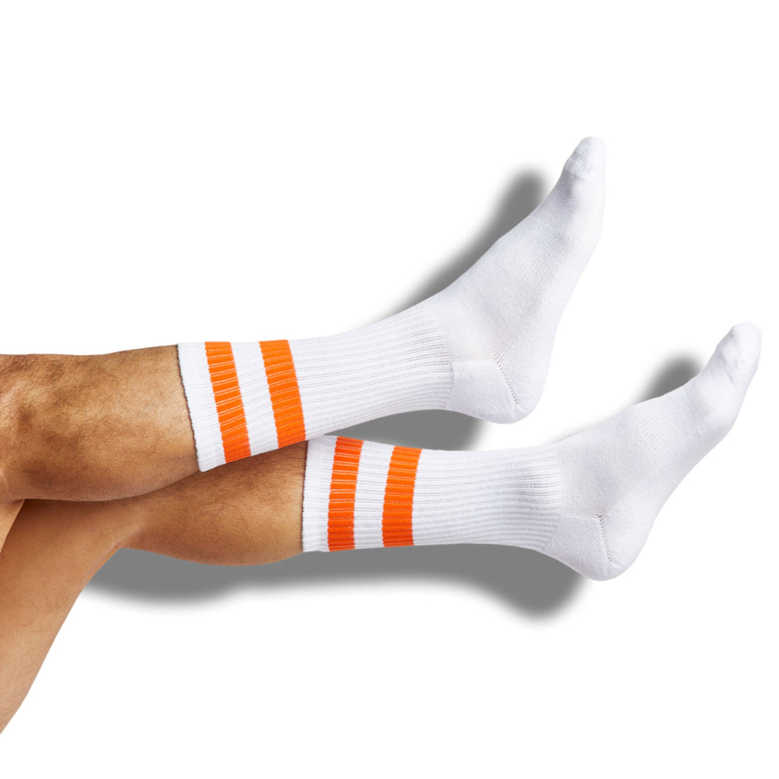 White casual crew socks with orange retro stripes shown on legs