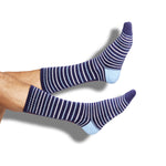 Navy athletic casual licensed Ole Miss socks with stripes in red and powder blue with Hotty Toddy going down the back of the leg shown leg.