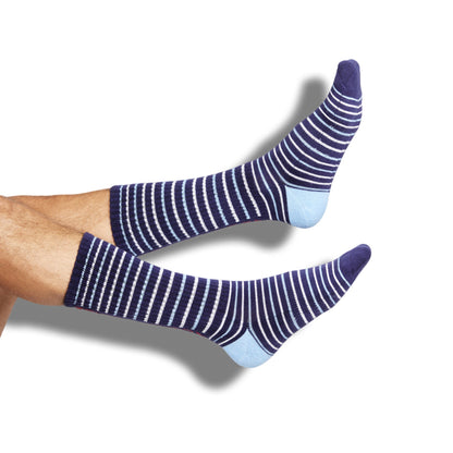 Navy athletic casual licensed Ole Miss socks with stripes in red and powder blue with Hotty Toddy going down the back of the leg shown leg.