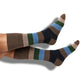 Brown, tan, green and navy striped dress socks on legs.
