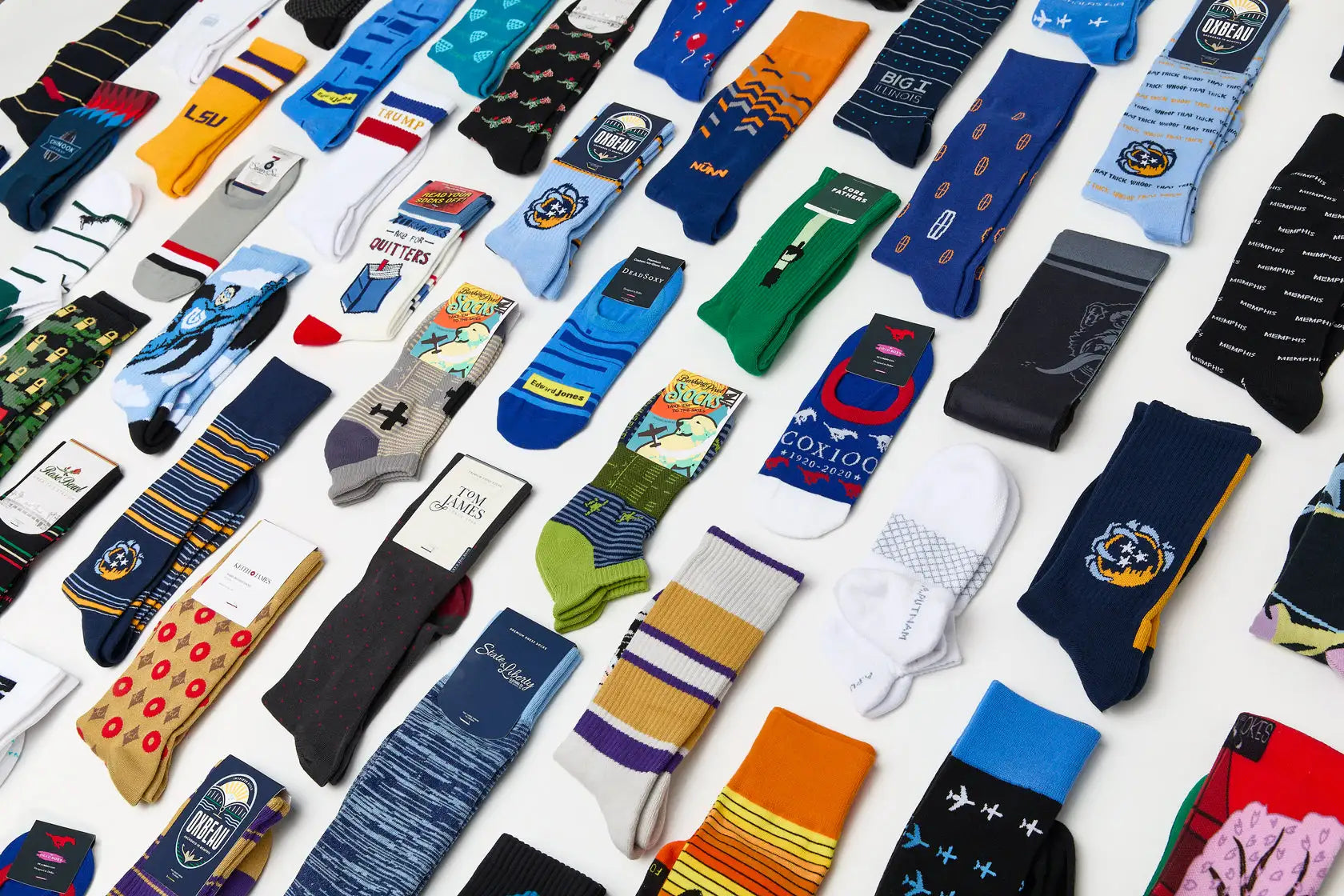 A vibrant collection of assorted crew socks featuring colorful patterns, team logos like lsu and nba teams, and branded designs from popular brands such as under armour.