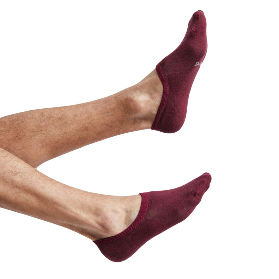The bac a deep red no show socks on feet coming into the image from the left