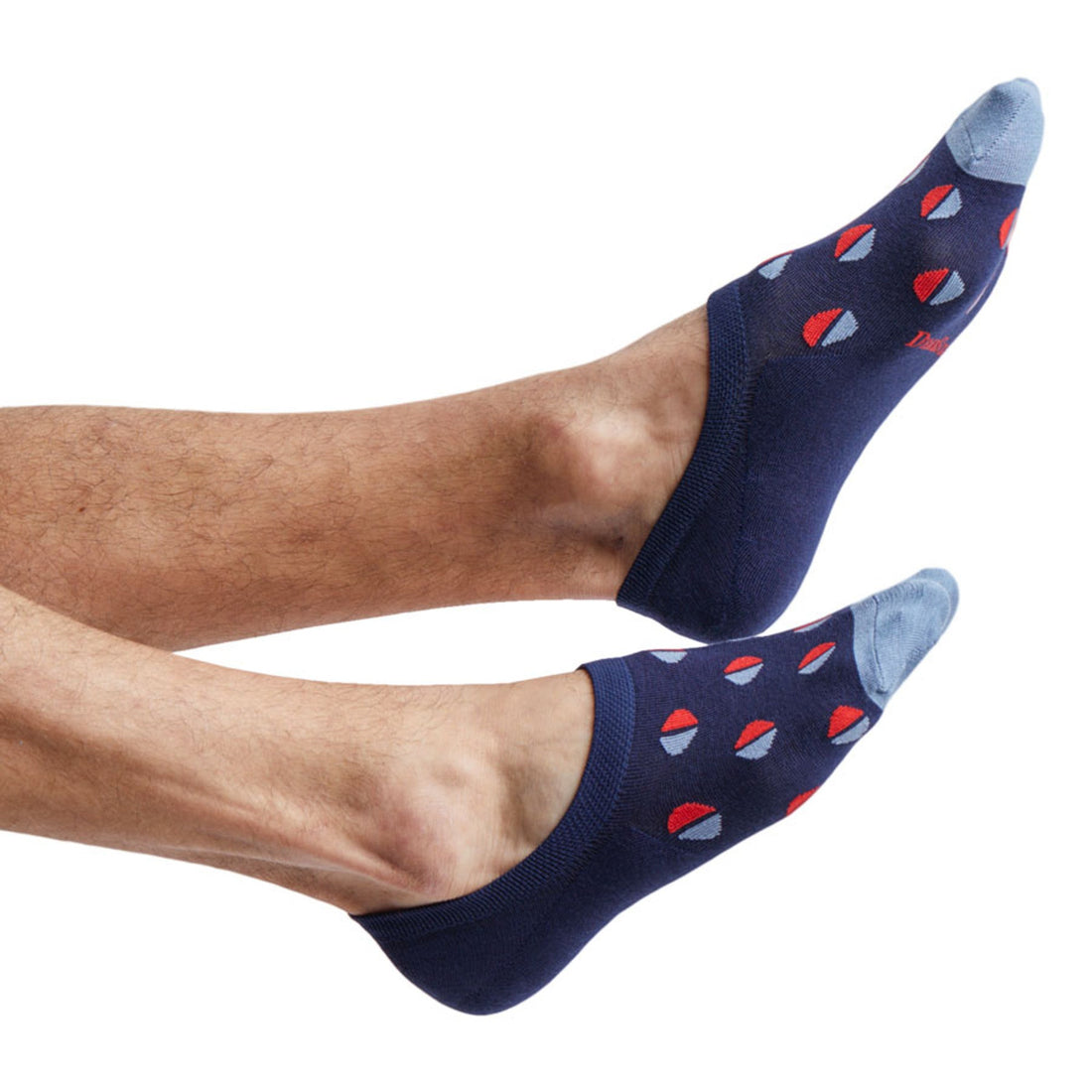 The phillips navy no show socks with medium sized dots half red and half powder blue on feet coming into the image from the left
