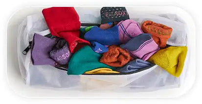 A white mesh laundry bag filled with colorful, folded socks of various patterns and hues.