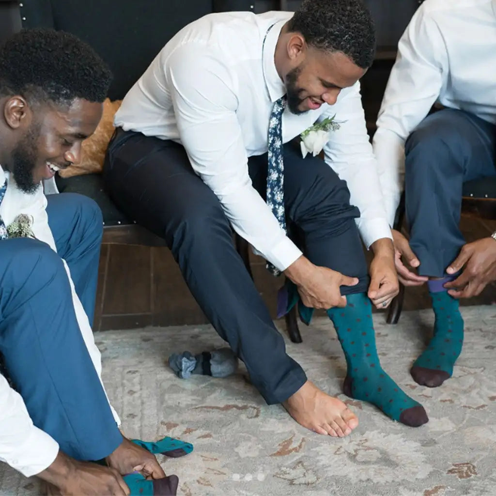 A groom and his friends getting ready in matching teal patterned socks